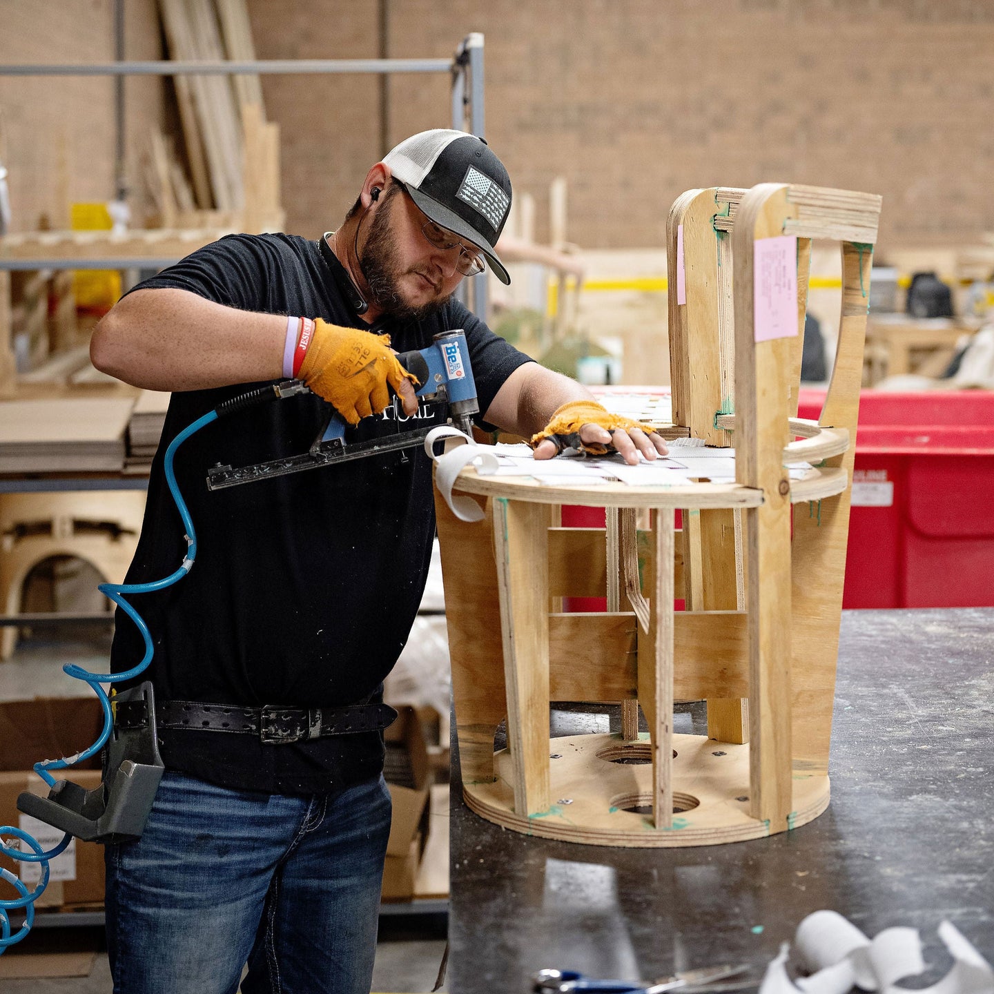 Person working on a wooden chair in a workshop