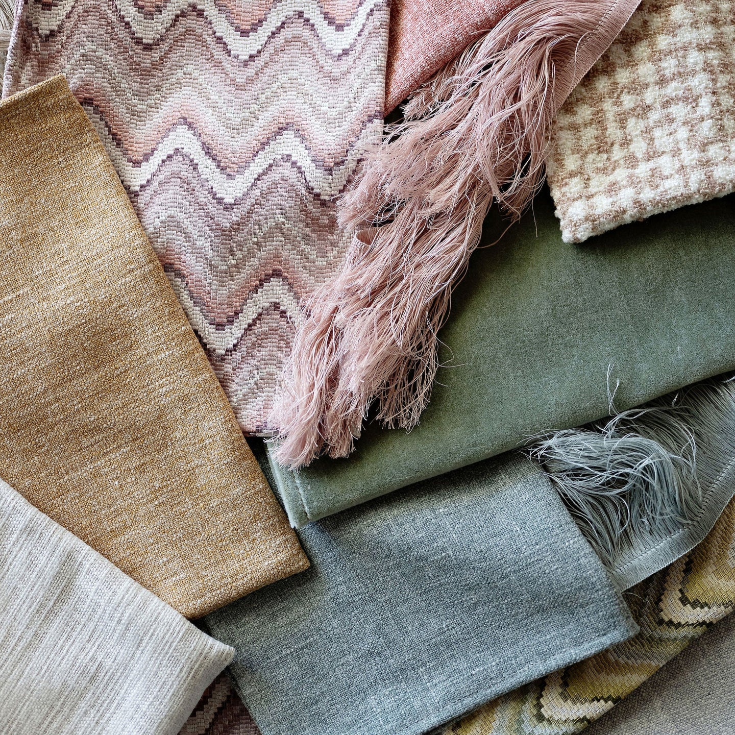 Collection of various textured fabrics in soft colors.