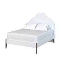 Coley Home scalloped upholstered bed with white bedding and wooden legs.