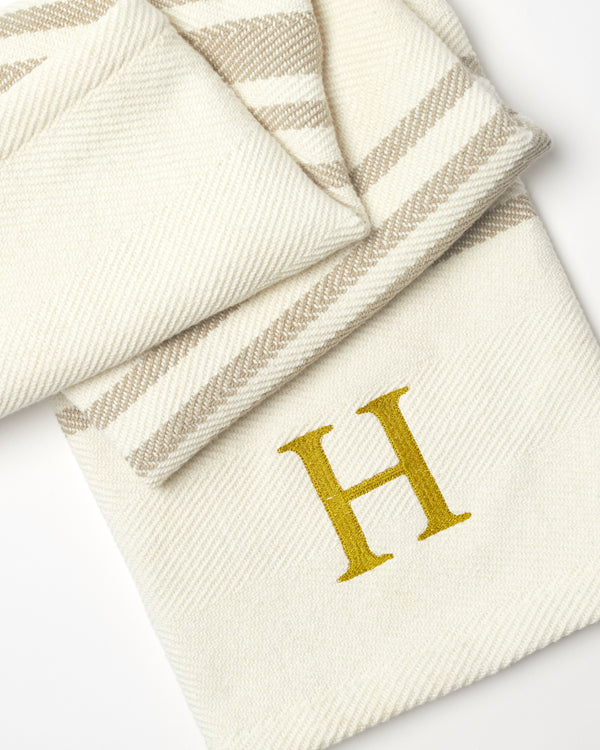Cream and beige striped blanket with monogrammed letter H from Coley Home.