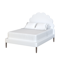 Coley Home scalloped bed with white linens and wooden legs.